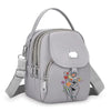 Sac bandoulière floral gris clair et durable avec fermeture éclair et sangle réglable.