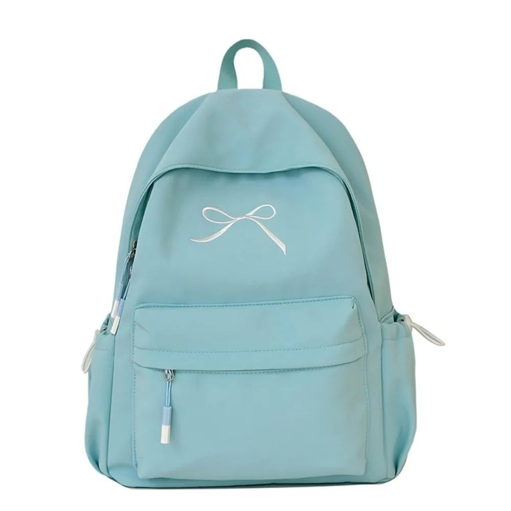 A light blue embroidered nylon backpack with a drawstring closure and multiple pockets.