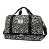 A black and white leopard print travel duffel bag with handles and a shoe compartment.