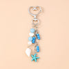 Silver keychain featuring a starfish charm and various blue and white pearl-like beads.