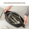 Une main ouvre un sac isotherme portable de grande capacité pour révéler une fourchette et des couverts à l'intérieur.