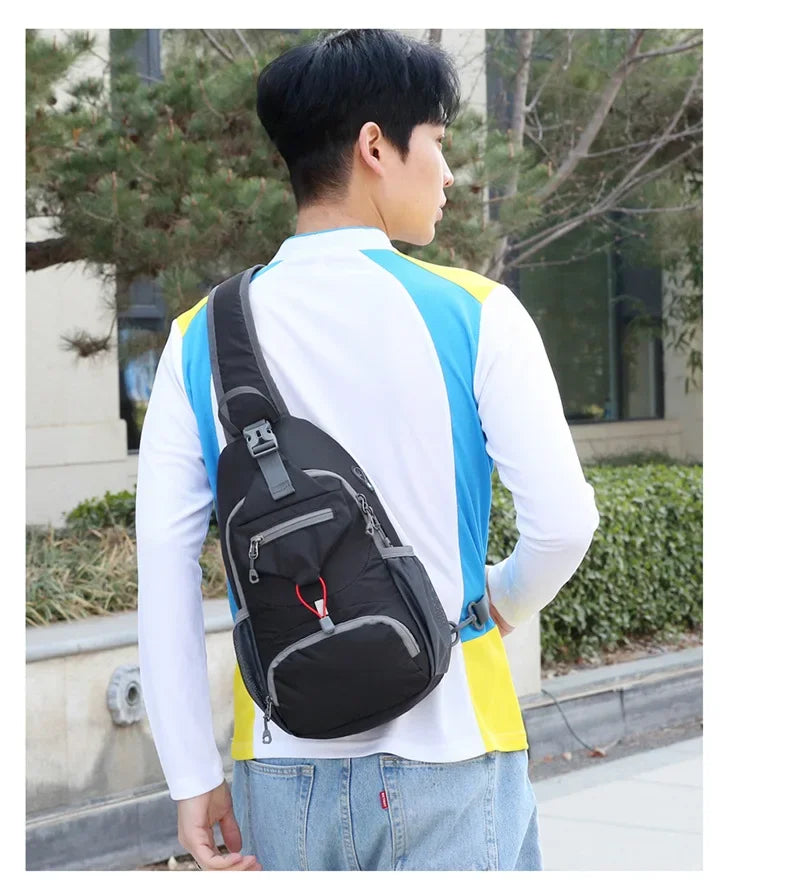 A person wearing a white shirt and jeans is shown from the back, carrying a black nylon chest sling bag with blue and yellow 