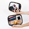 A hand holds a leopard print waterproof cosmetic organizer bag containing various makeup products.