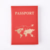 A red leather passport holder with gold foil printing of the world map and the word PASSPORT.