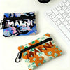 A floral print mini coin purse with a black carabiner clip resting on a white surface.