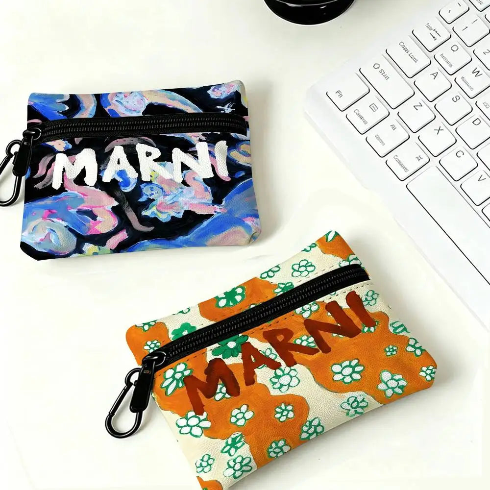 A floral print mini coin purse with a black carabiner clip resting on a white surface.