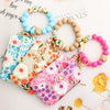 A collection of silicone bead and PU leather key chain wallets and bracelets displayed on a white background.