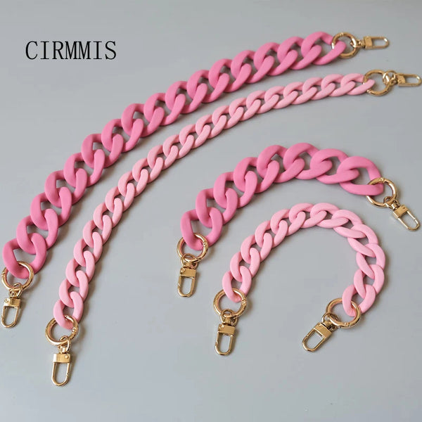 A pink resin chain necklace with gold clasps displayed on a gray background.