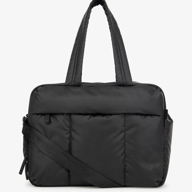 A black large capacity women's travel duffle bag with a padded design.