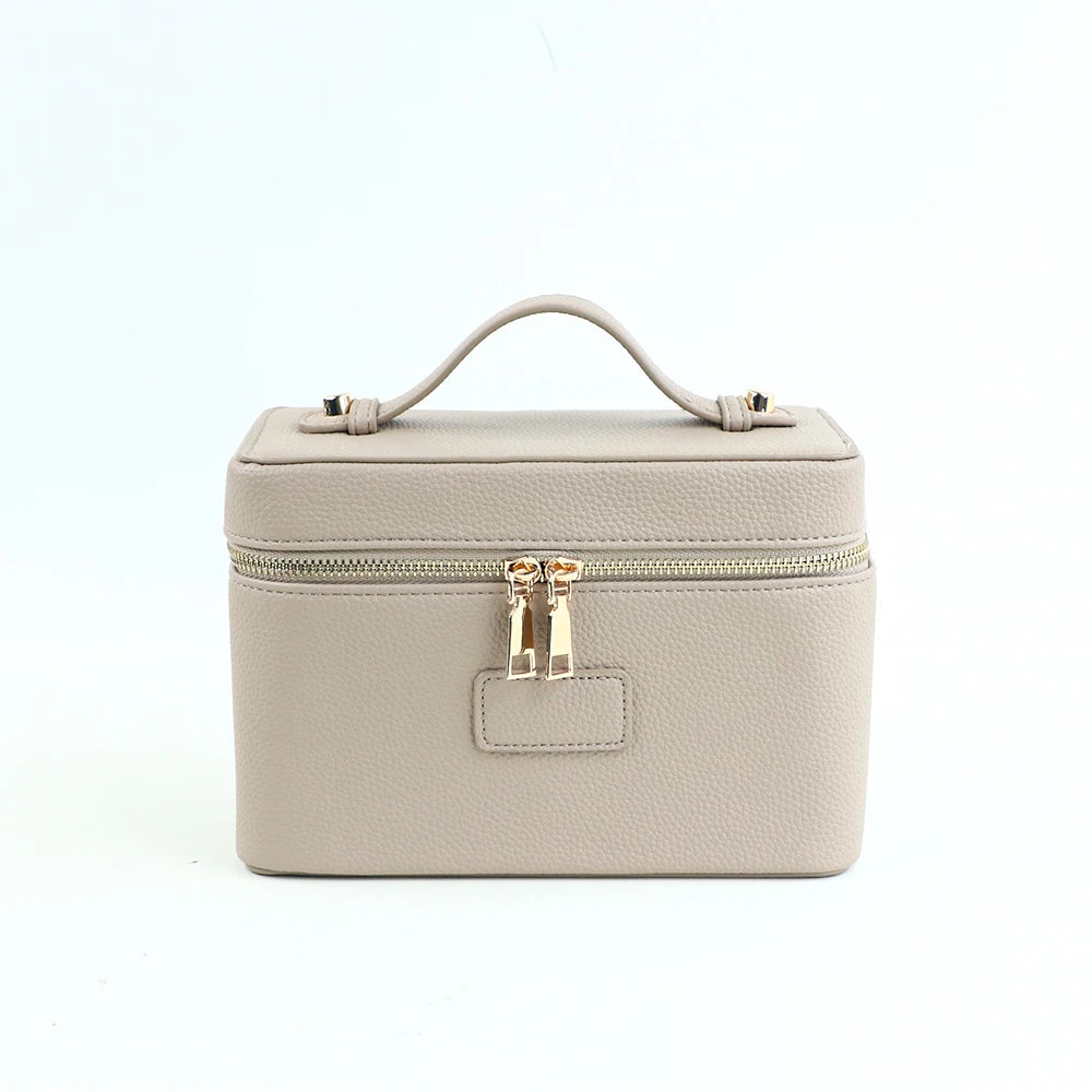 A beige PU leather makeup bag with a top handle and zipper closure.
