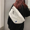 Weißes gestepptes Mode-Chest-Bag, getragen von einer Person in einem schwarzen Oberteil.