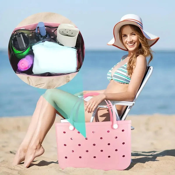 A woman relaxing on the beach holding a pink transparent bag organizer with dividers and various items.