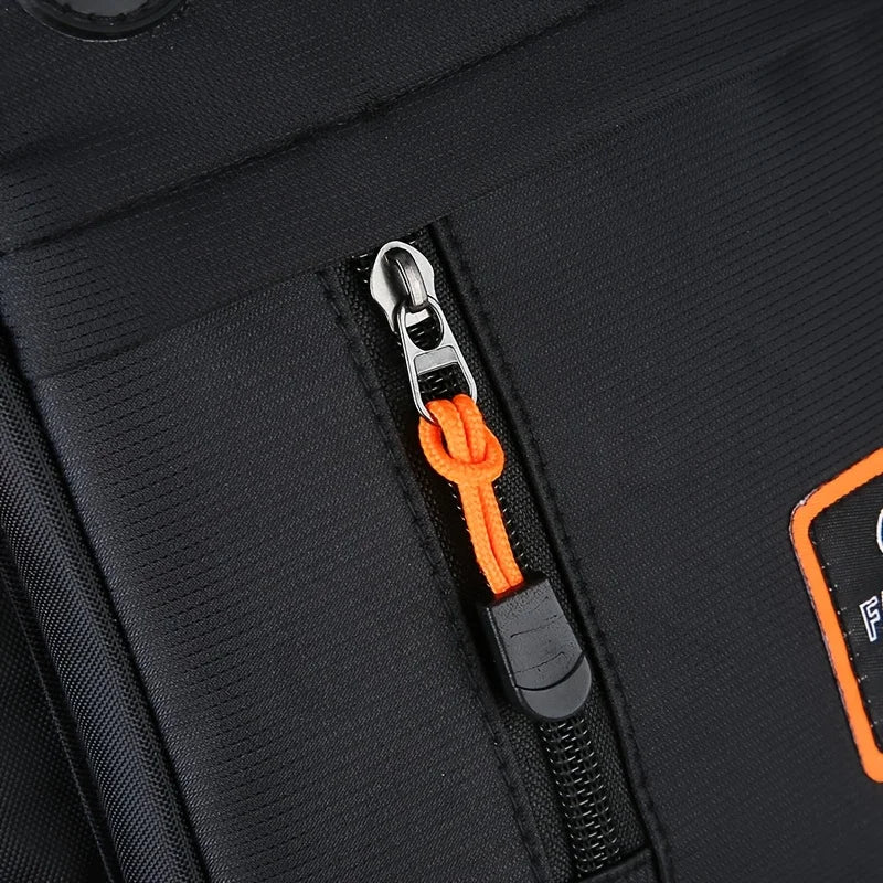 Close-up of a black crossbody sling bag featuring an orange cord and zipper detail.