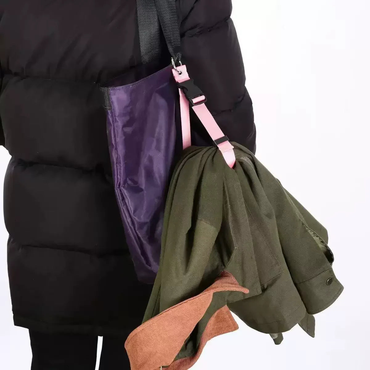 Un blouson matelassé noir avec un sac violet suspendu à une sangle réglable.