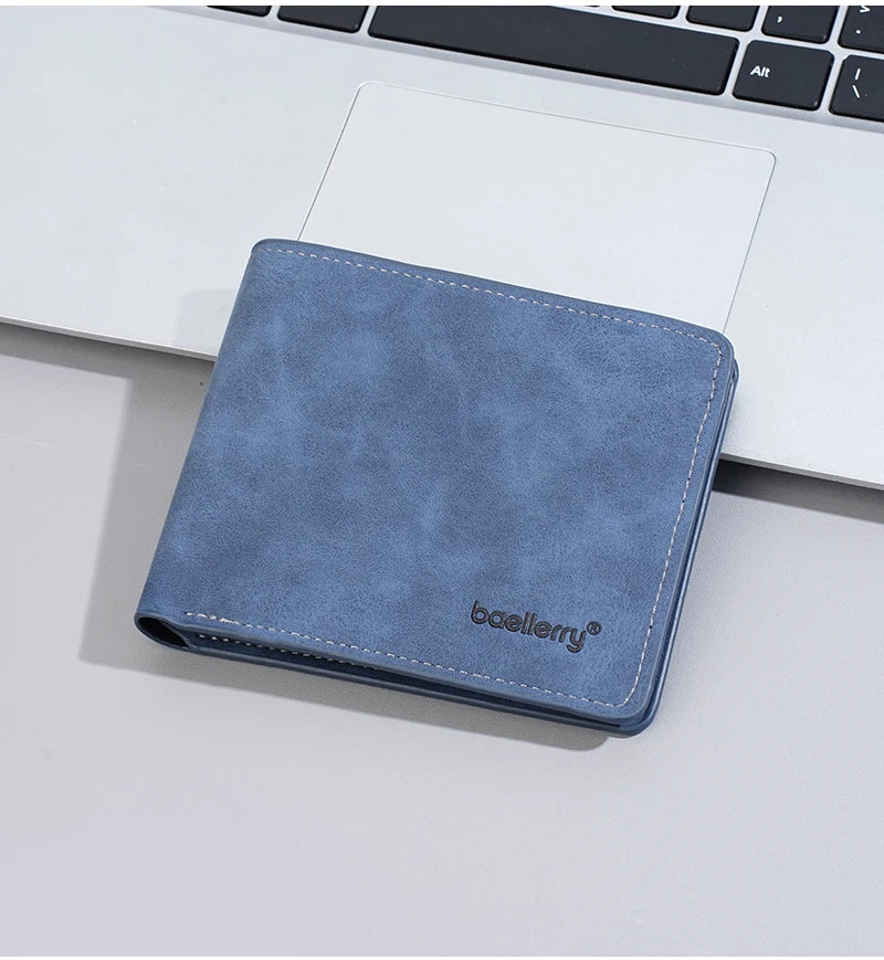 Un porte-cartes en cuir bleu reposant sur un clavier d'ordinateur portable blanc.