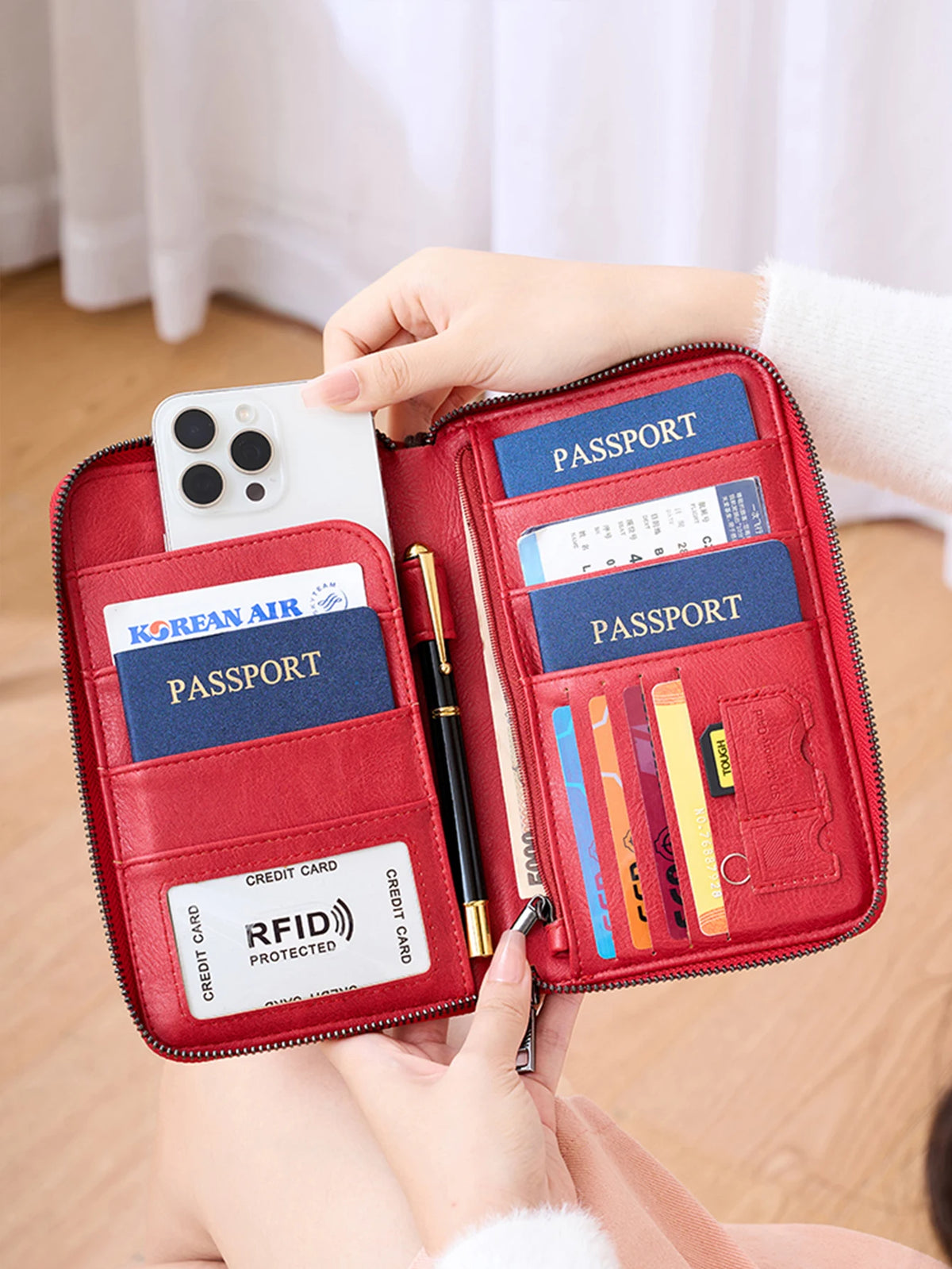 A red RFID blocking travel wallet is shown open, displaying passport and credit card slots.