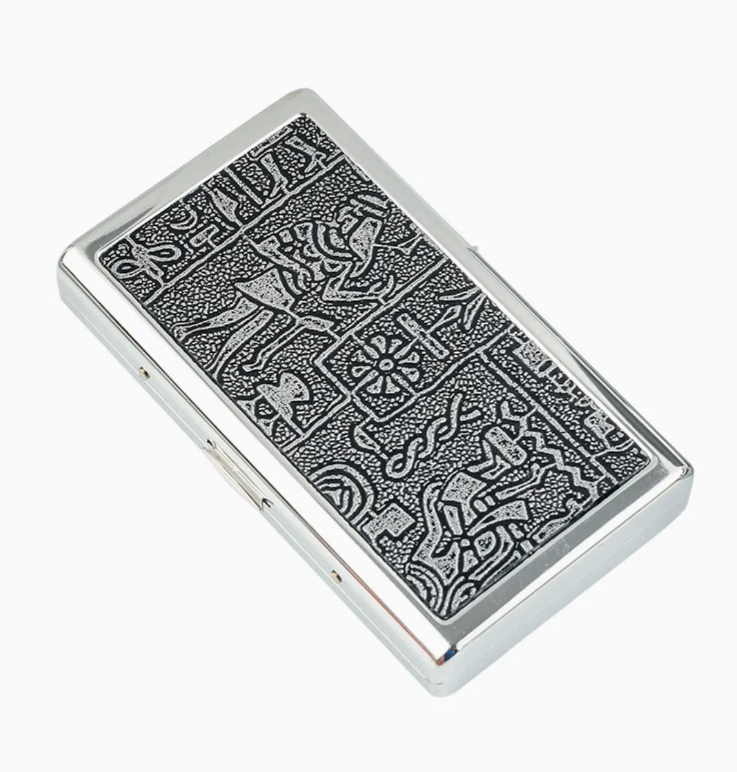A rectangular silver metal cigarette holder featuring intricate engraved patterns.