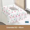 A rolled disposable toilet seat cover in pink and green floral pattern displayed on a white surface.