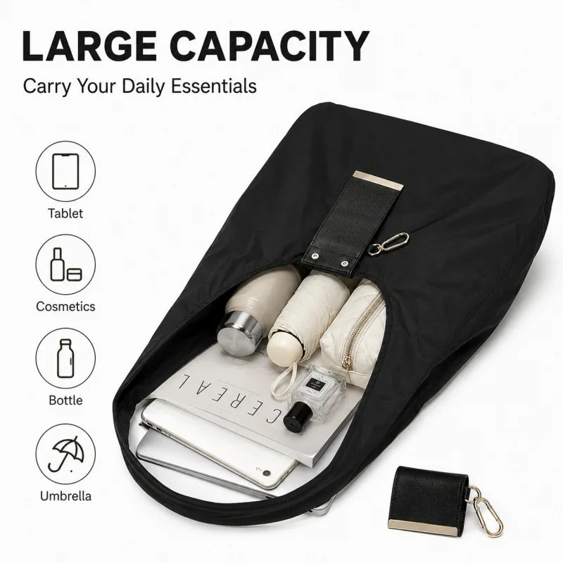 Sac de courses noir en nylon pliable ouvert, contenant des essentiels quotidiens comme une tablette, des cosmétiques et des b