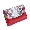 A red leather mini card holder wallet featuring a patterned faux crocodile skin on the exterior.