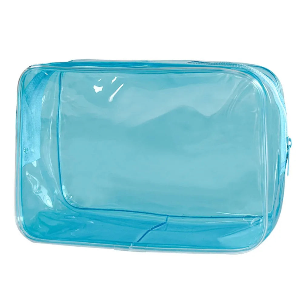 A clear blue transparent PVC travel makeup bag with a zipper closure.