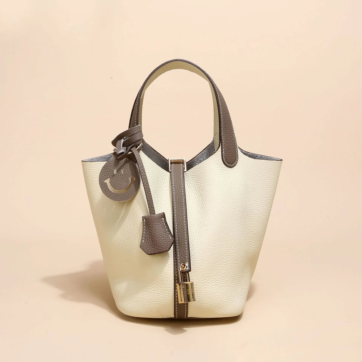 Beige Leder-Korbtasche mit Schnurverschluss und hellbraunem Zierrand.