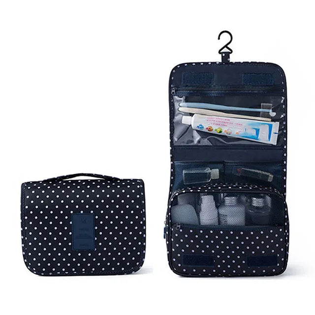 A dark blue multi-compartment travel pouch with a floral print and a hanging loop.