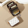 A brown zippered card holder wallet filled with cash and several credit cards rests on a beige surface next to a white box an
