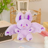 A fluffy purple bat bunny plush toy with purple accents sitting on a white surface.