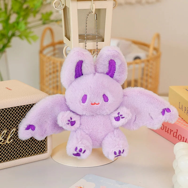 A fluffy purple bat bunny plush toy with purple accents sitting on a white surface.