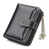 A black leather mini wallet with stitching and a gold clover charm.