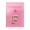 A pink leather passport holder with a gold initial F embossed on it and a pink airplane symbol.