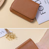 A brown leather ultra-thin wallet is shown being held by a hand, with a card visible next to it.