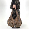A brown leopard print crossbody shoulder bag with multiple compartments being held by a person.