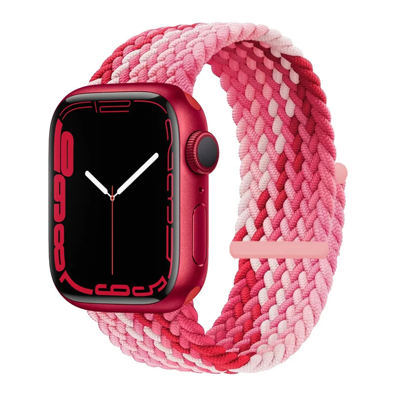 A pink and red braided stretch band is shown around a red Apple Watch.