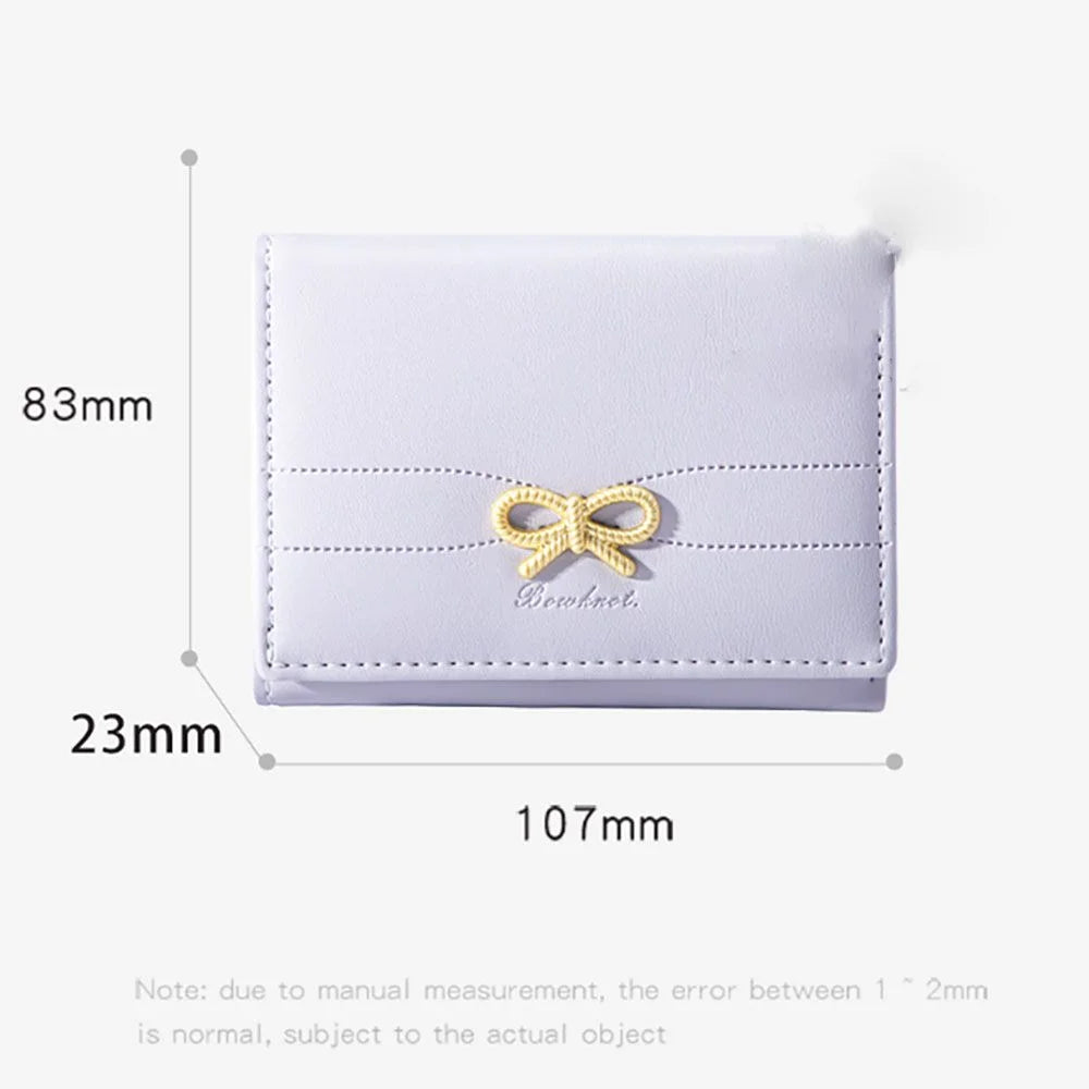 Cartera de cuero PU blanca tríptico con detalle de cinta dorada, mostrada contra una regla de medición.