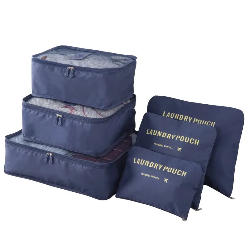 A set of navy blue mesh packing cubes, including a zippered storage box and several flat pouches, for travel organization.