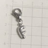 Silver stainless steel alphabet letter charm with a lobster clasp placed on a ruler.