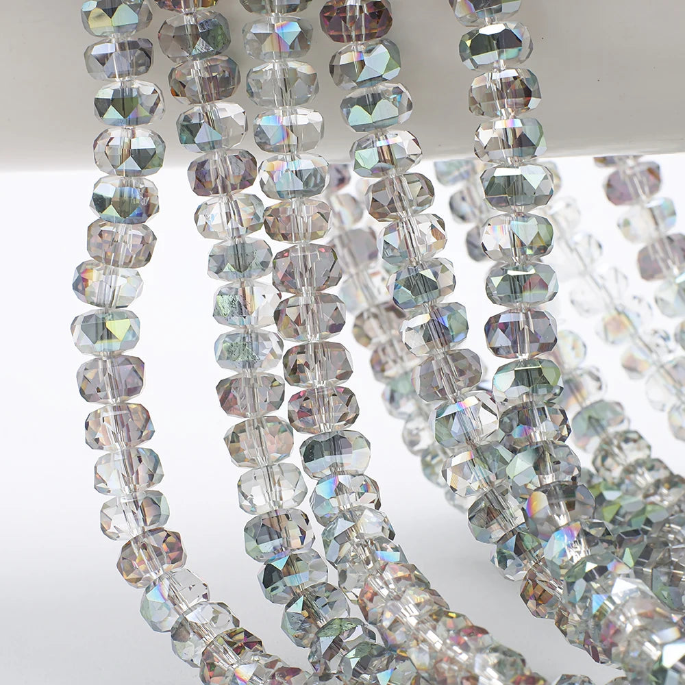 A close-up of strands of clear and iridescent faceted crystal glass beads in a wheel shape for jewelry making