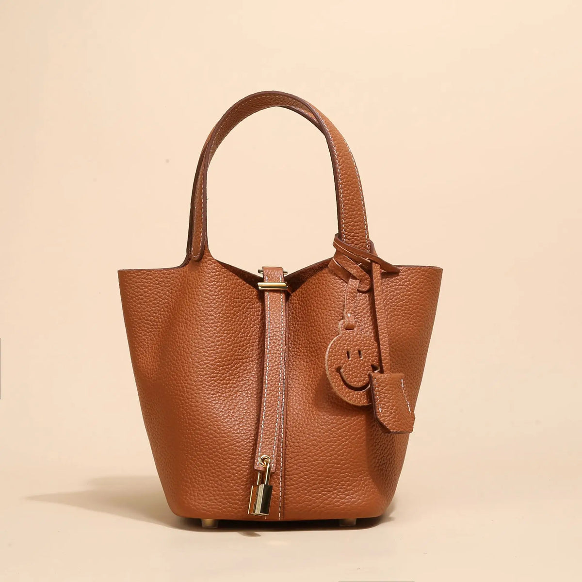 Braune Leder-Bucketbag mit gebogener Henkel und kleinem gesticktem Smiley-Gesicht