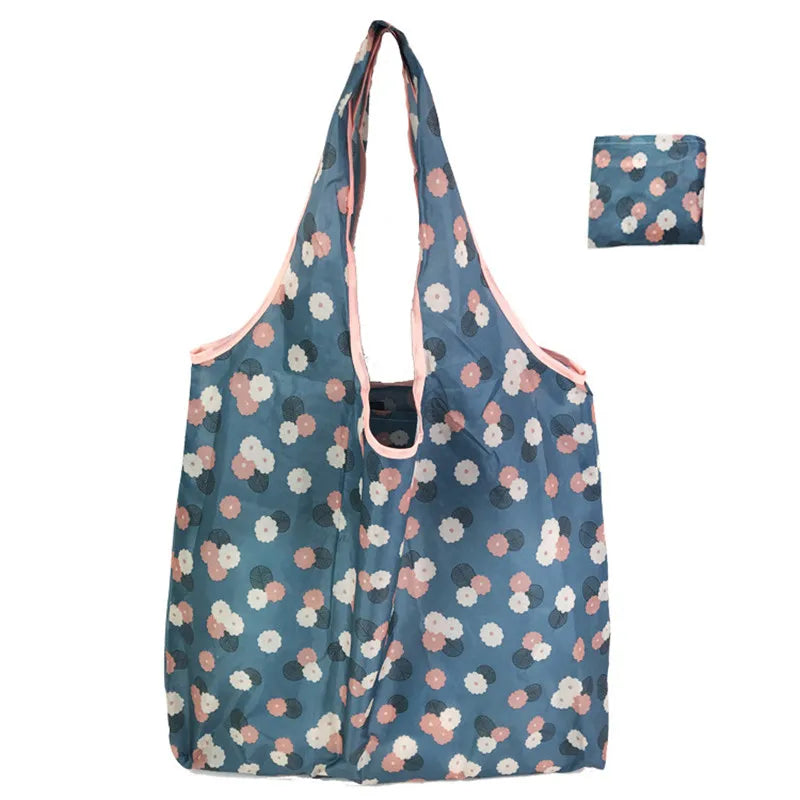 A reusable nylon tote bag with a blue and pink floral pattern shown in a vertical orientation.