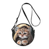 A round black crossbody bag featuring a cartoon kitten with tabby stripes and yellow accents.