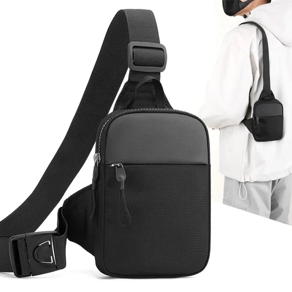 A black canvas crossbody sling bag is shown with a strap and a person wearing a white hoodie.