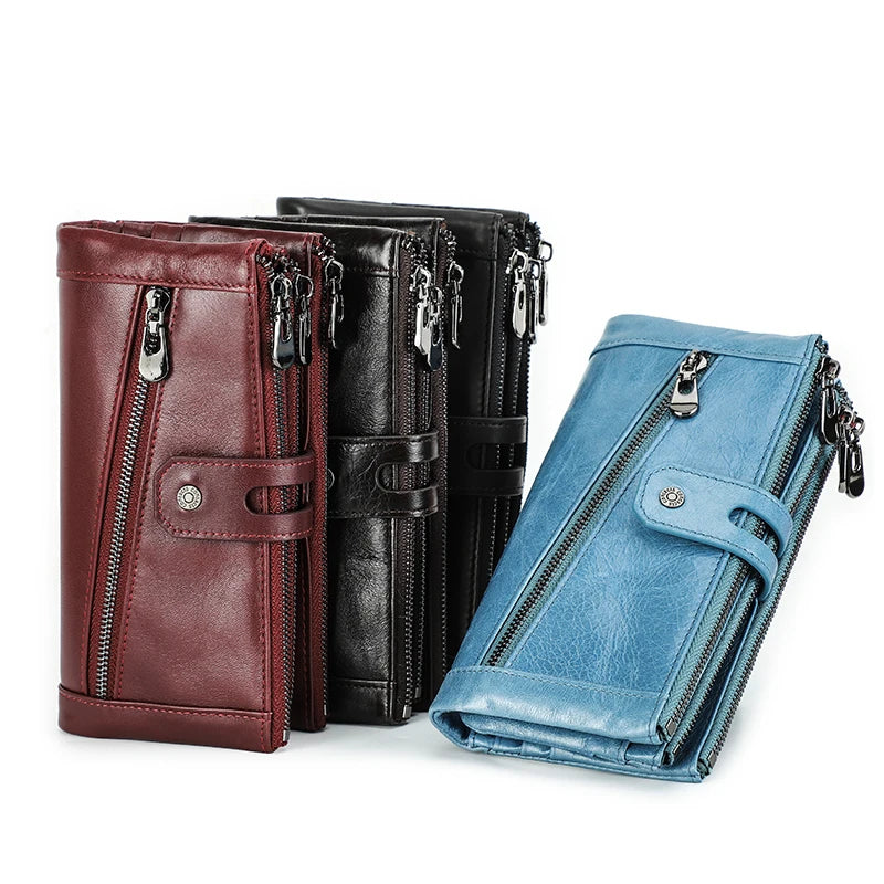 Three genuine leather vintage clutch wallets in maroon, black, and blue stacked together.