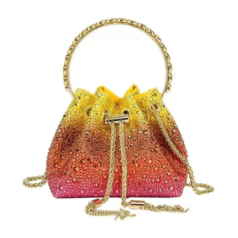 A gold chain crystal-embellished evening clutch bag with a shimmering pink and gold gradient finish.