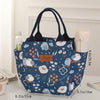 Una bolsa térmica azul oscuro con estampado floral junto a un recipiente de color claro.