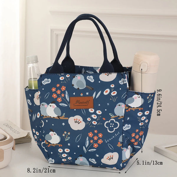 A dark blue thermal bento bag with a floral pattern is shown next to a light-colored container.