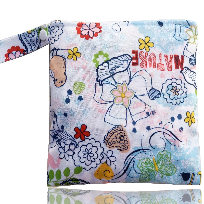 A colorful fabric reusable waterproof snack bag with a floral and nature print.
