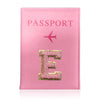 A pink leather passport holder with the embossed letter E and a small airplane symbol.