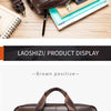 A brown genuine cowhide leather briefcase bag displayed with various accessories on a wooden surface.